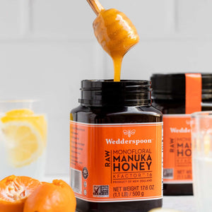 Wedderspoon Raw Manuka Honey KFactor 16 Six Pack jars with honey dipper pouring honey