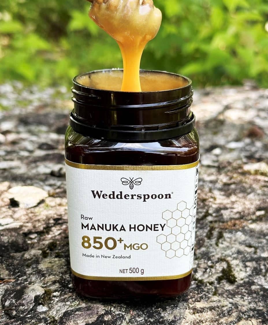 Wedderspoon Raw Manuka Honey MGO 850 plus jar with honey dripping outdoors awarded best edible face mask 2024