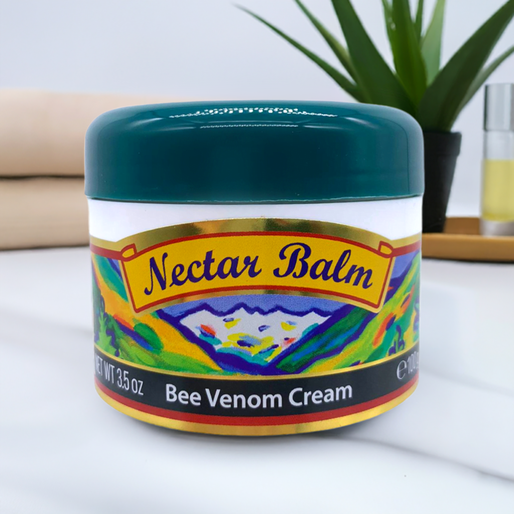 Nectar Balm jar of manuka honey bee venom cream with teal lid on white marble surface