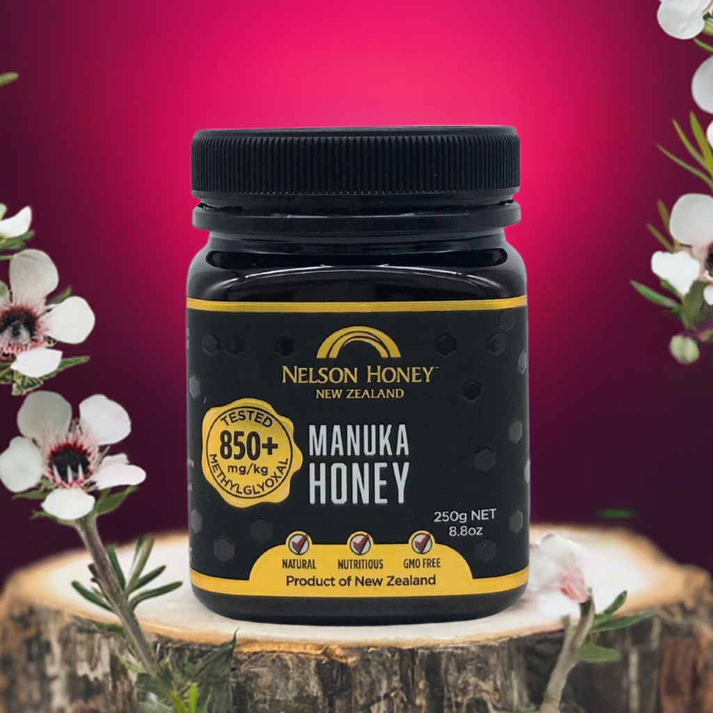 Nelson Manuka honey MGO 850+ 250g black jar by Nelsons Honey on wooden stump with manuka flowers