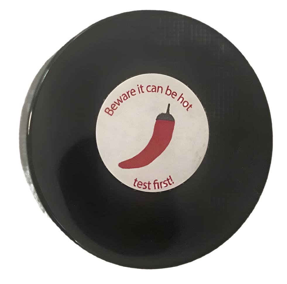 PowerHealth chilli hot balm for muscle aches in a black round container with warning label
