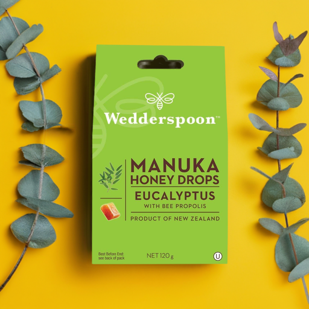 Wedderspoon manuka honey eucalyptus drops throat lozenges box with eucalyptus leaves on yellow background