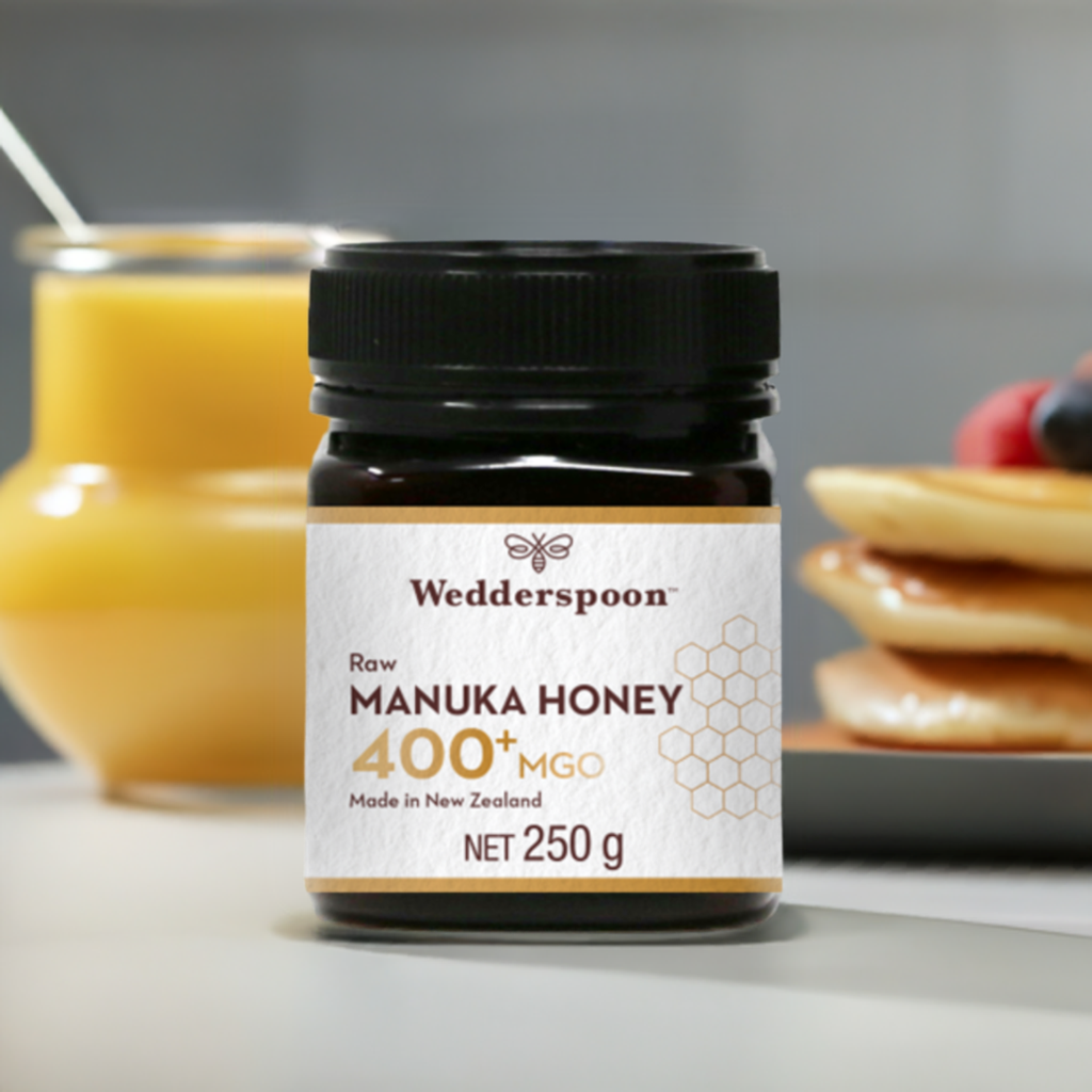 Wedderspoon Raw Manuka Honey 400 MGO 250g Unpasteurised jar with breakfast background