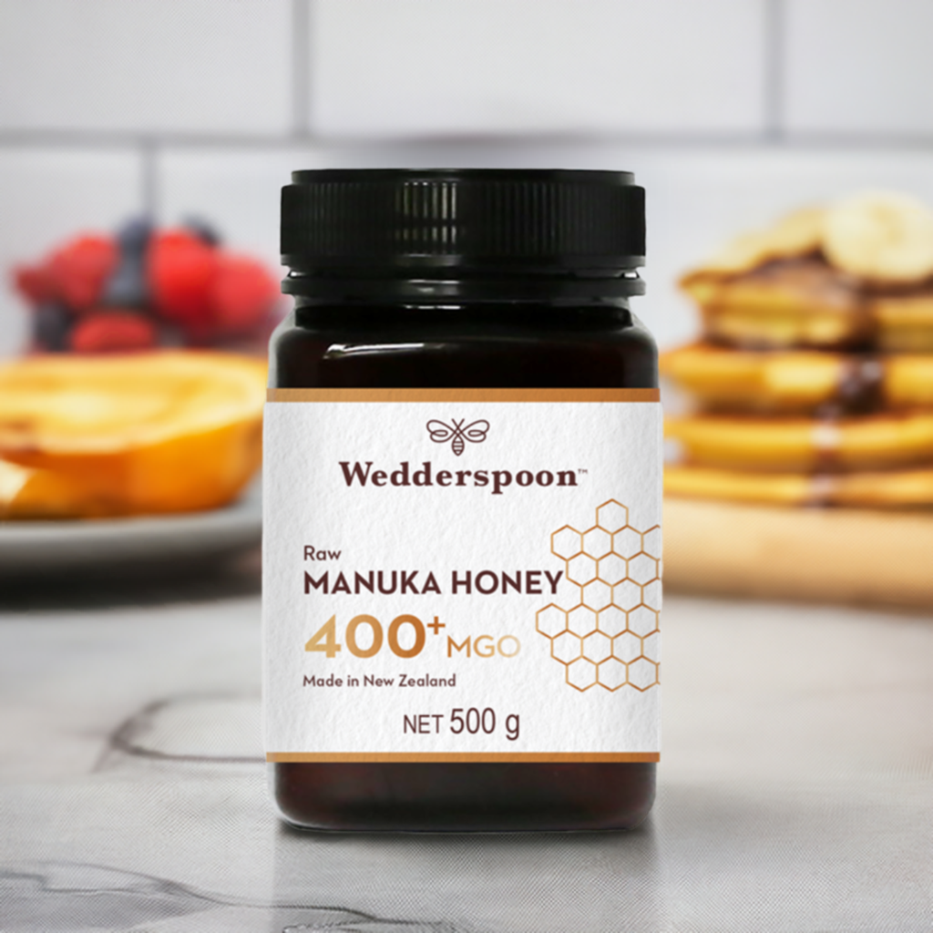 Wedderspoon Raw Manuka Honey 400 MGO 500g jar with black lid on kitchen counter