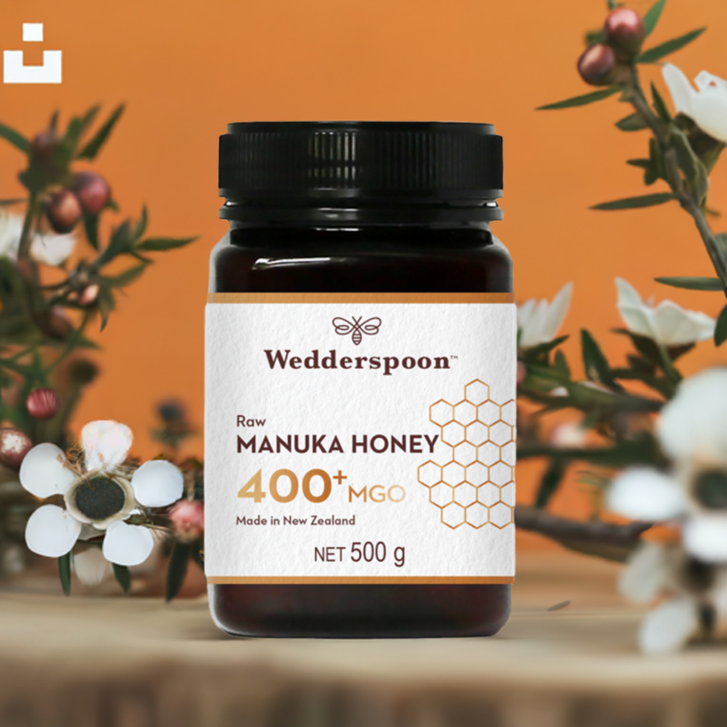 Wedderspoon Raw Manuka Honey 400 MGO 500g jar with floral background and orange backdrop