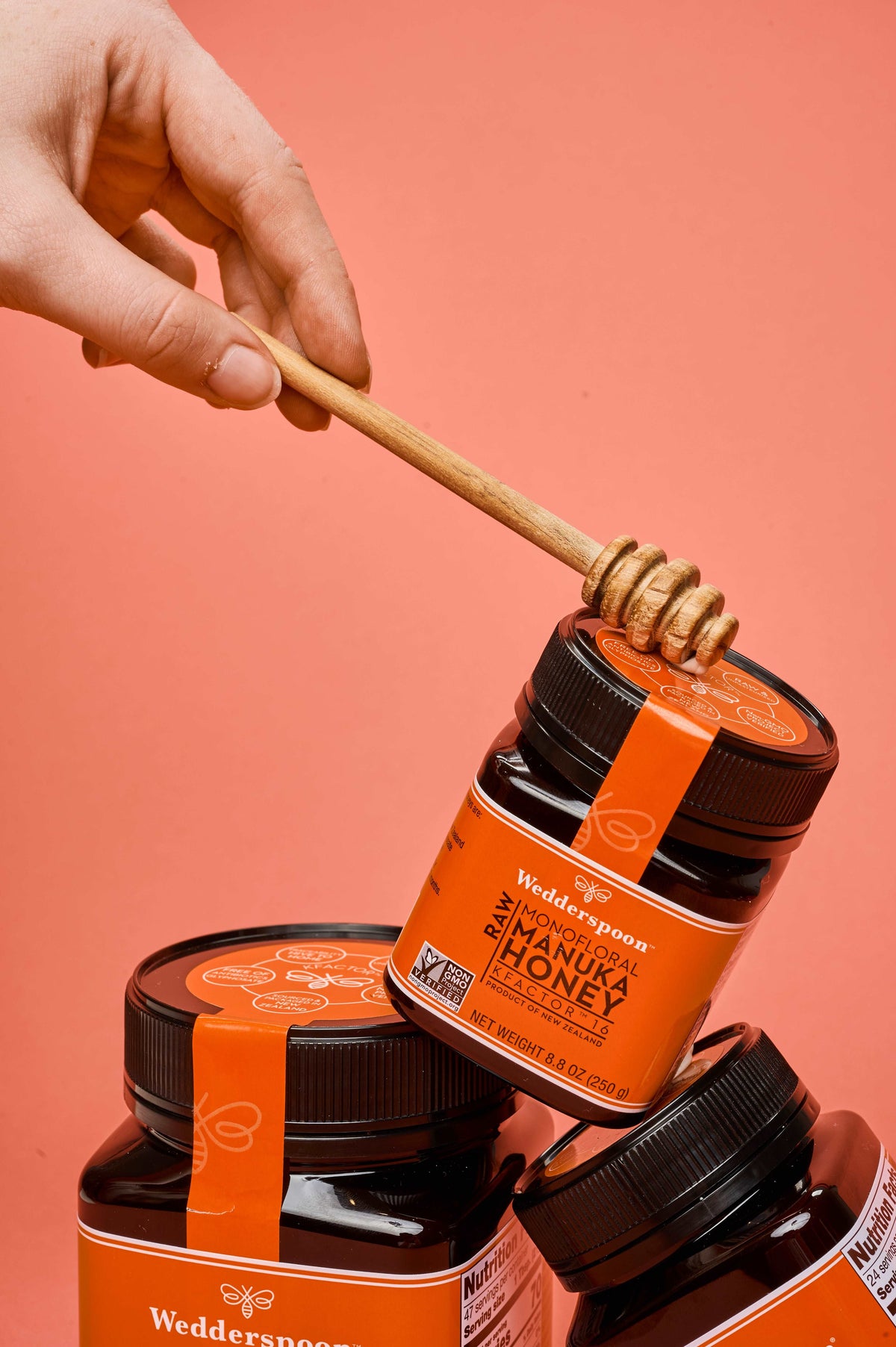 Wedderspoon Raw Manuka Honey KFactor 16 500g Triple Pack jars with wooden honey dipper over one jar