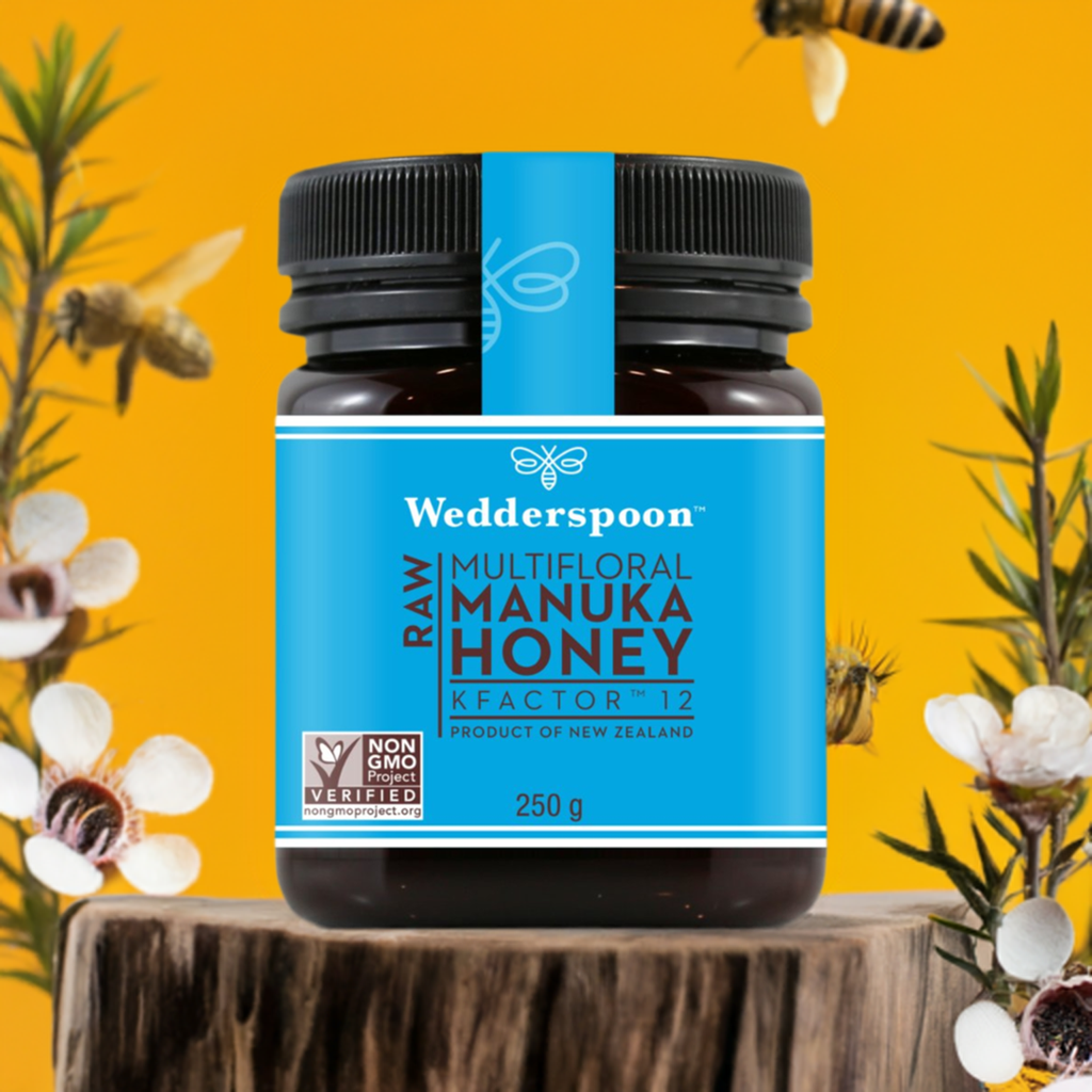 Wedderspoon Raw Manuka Honey Triple Pack jar with blue label on wooden stump and bees flying around